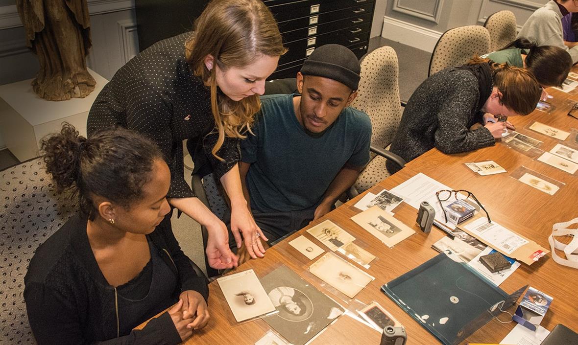 Amber Kehoe of the Winterthur/University of Delaware Program in Art Conservation talks with Allison Robinson (left) and Ethan Barnett as they study the photographs and provenance of the Baltimore Collection.